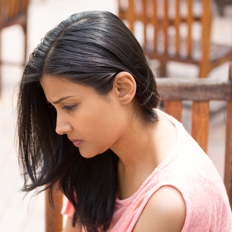 woman looking down with a serious look on her face